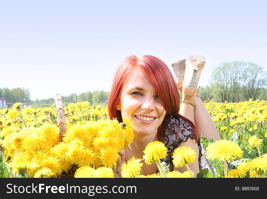 Beautiful redhead girl with basket of dandelions. Beautiful redhead girl with basket of dandelions