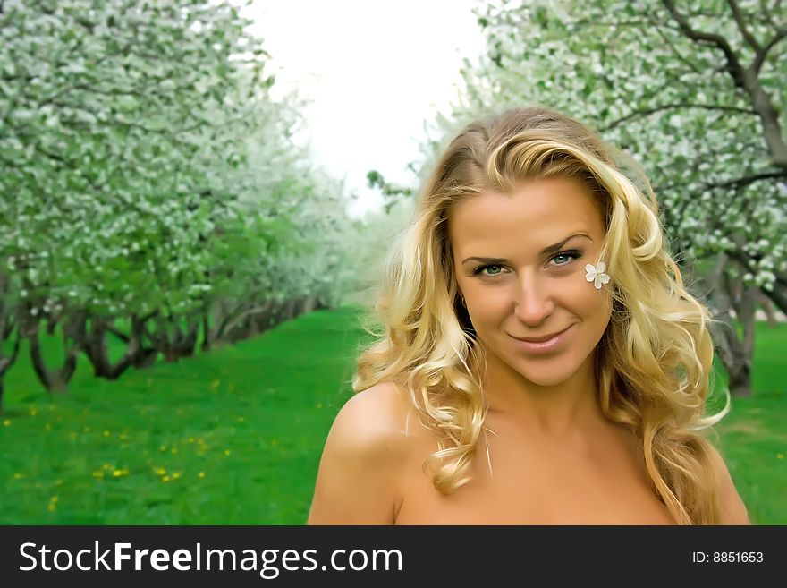 Beautiful girl with blonde hair in the cherry garden