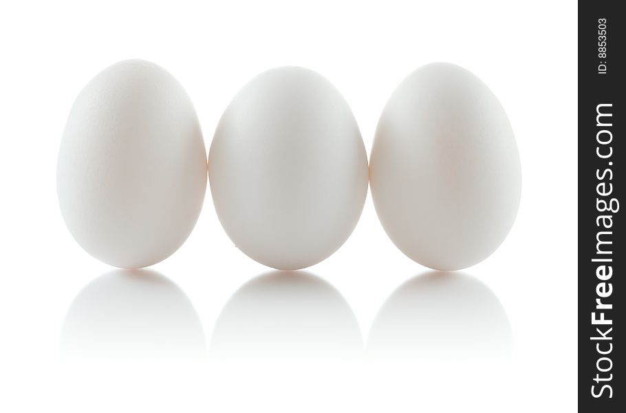Three isolated chicken eggs in a row