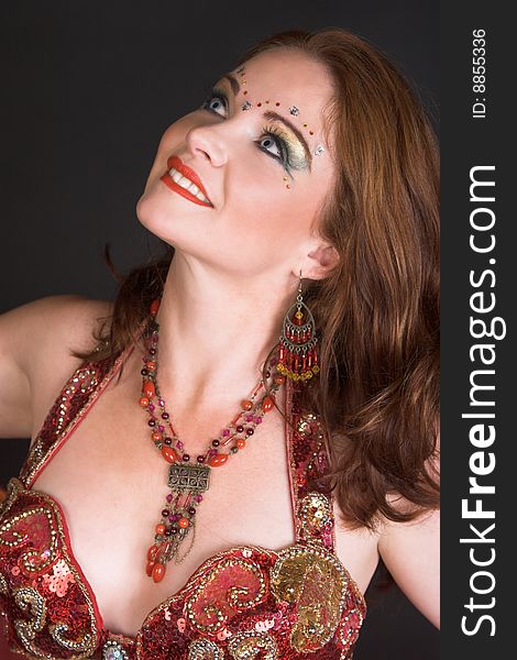 Belly Dancer wearing a red costume with jewelery. Belly Dancer wearing a red costume with jewelery