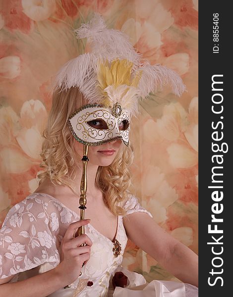 Beautiful model wearing a wedding dress and Venetian mask, studio. Beautiful model wearing a wedding dress and Venetian mask, studio