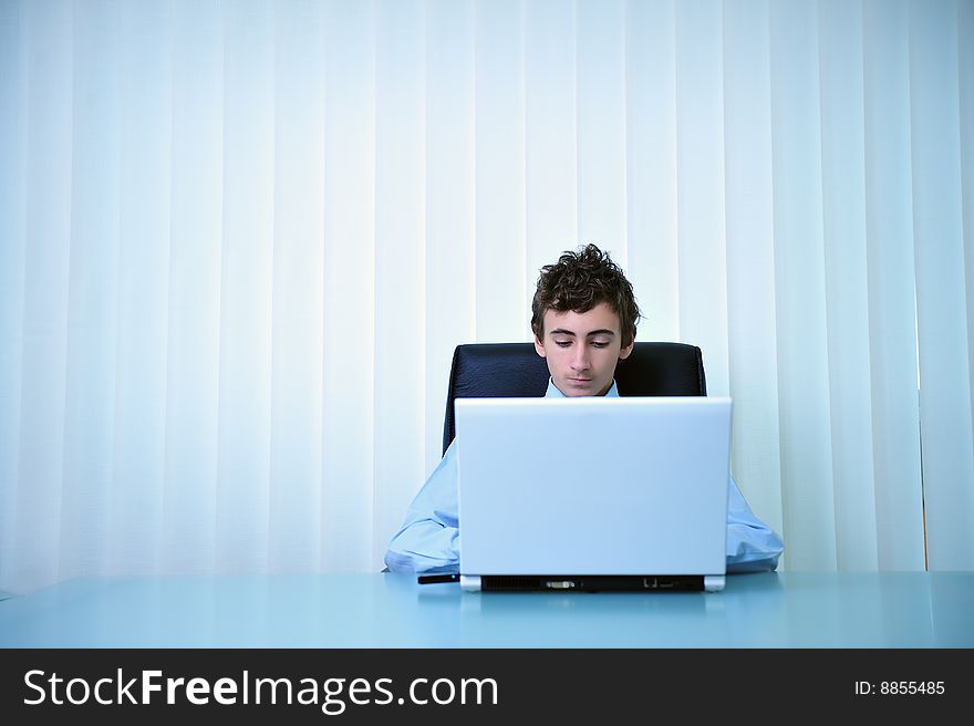 Young businessman using computer laptop in office. Young businessman using computer laptop in office