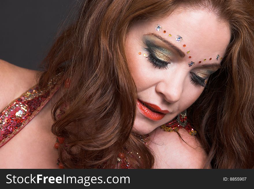 Belly Dancer wearing a red costume with jewelery. Belly Dancer wearing a red costume with jewelery