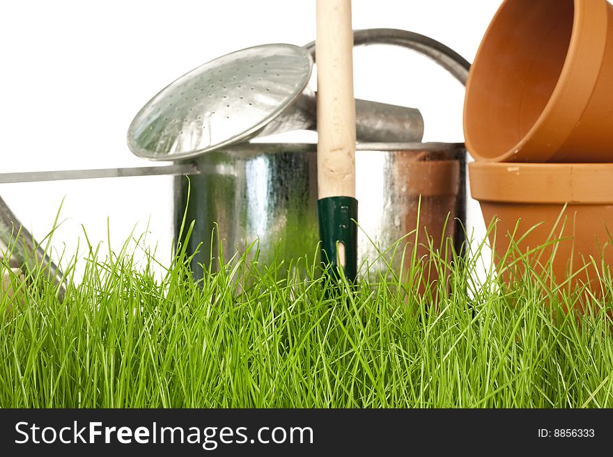 Spring gardening - grass and garden tools on white