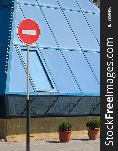Red forbidding traffic sign against blue windows of a building. Red forbidding traffic sign against blue windows of a building.