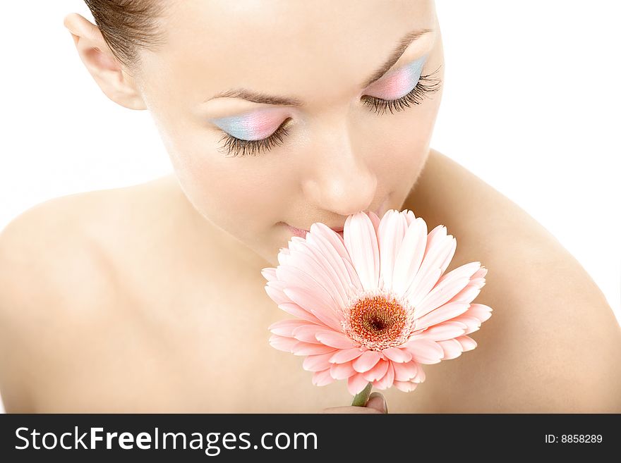 The girl smells pink gerbera on a white background