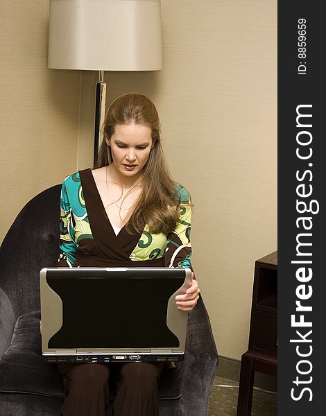 Young Female Sitting with Laptop Computer on Chair