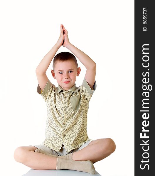 The boy sits in a pose of meditation