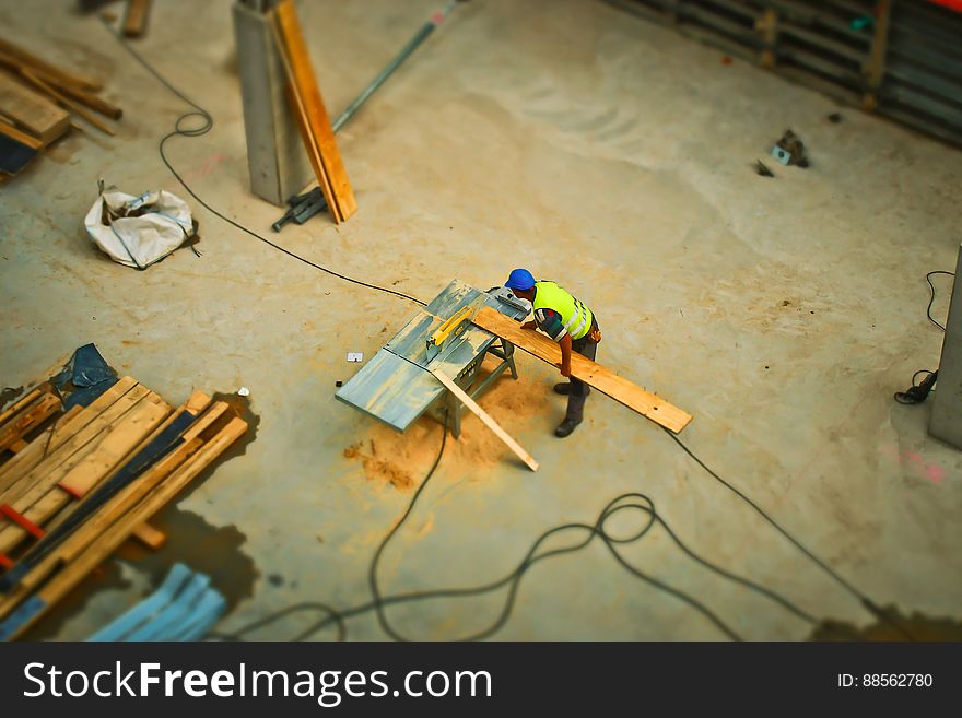 Person Cutting Wood on Table Saw during Daytime