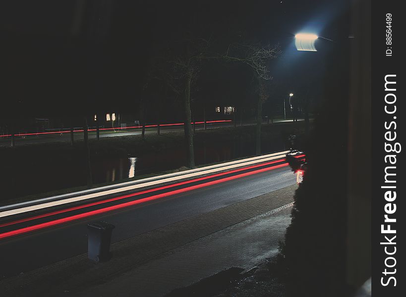 A long exposure of a street with light streaks from car lights at night.