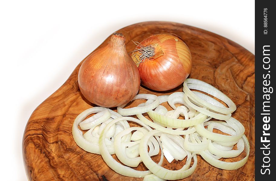 Whole yellow onions and onion rings on a cutting board. Whole yellow onions and onion rings on a cutting board.
