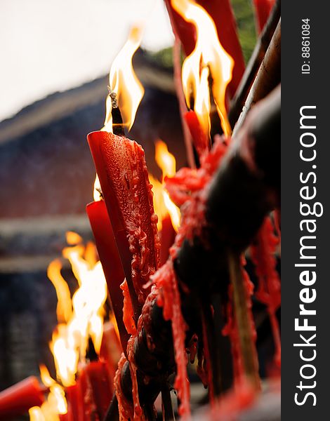 A picture of burning long red burning candles in chinese tample