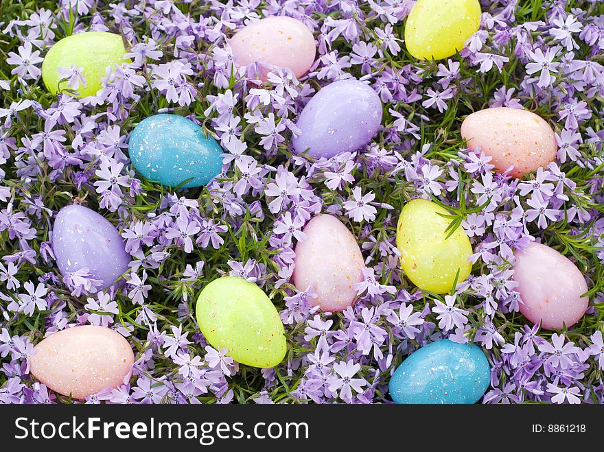 A colorful collection of Easter Eggs scattered on a background of fresh purple Phlox blooms. A colorful collection of Easter Eggs scattered on a background of fresh purple Phlox blooms