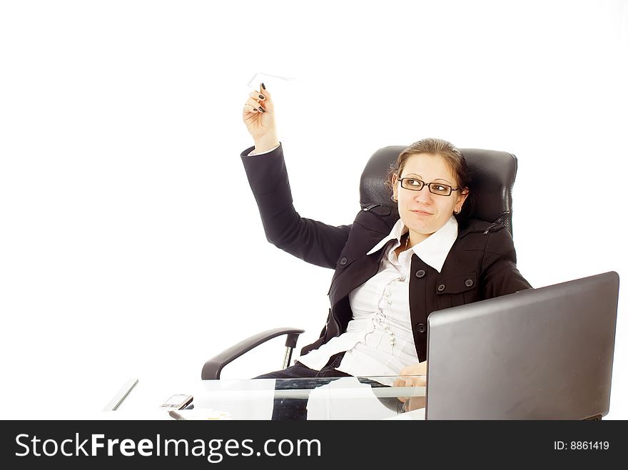A young business woman in her office with a paper plane. A young business woman in her office with a paper plane