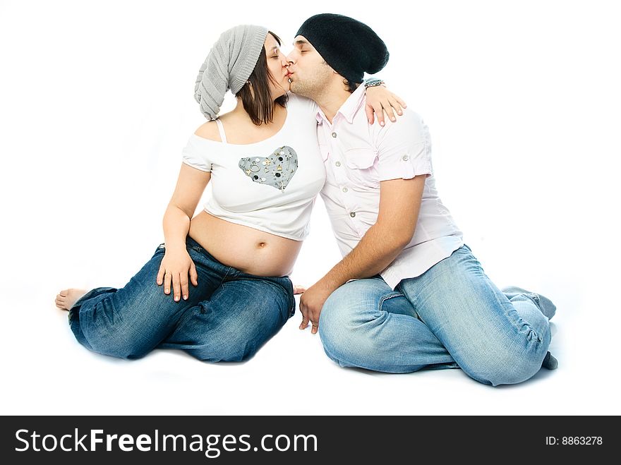 Happy family, young beautiful pregnant woman and her husband embracing and kissing. Happy family, young beautiful pregnant woman and her husband embracing and kissing