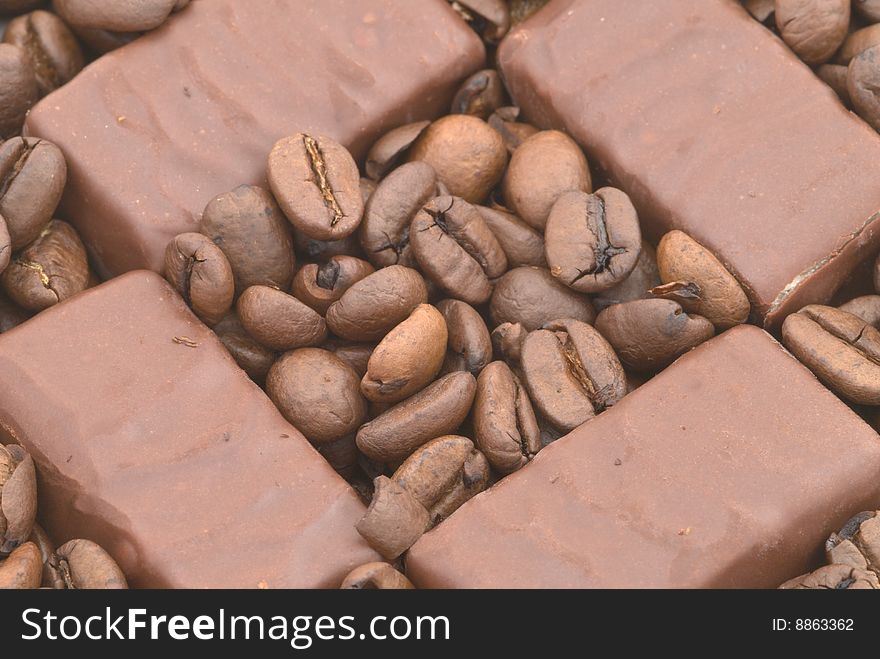 Chocolate on the coffee beans background. Chocolate on the coffee beans background