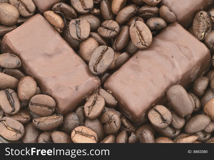 Chocolate on the coffee beans background. Chocolate on the coffee beans background