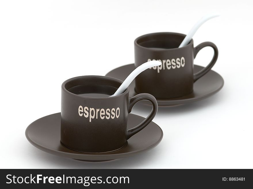 Coffee cups with white tea-spoons. Selective focus