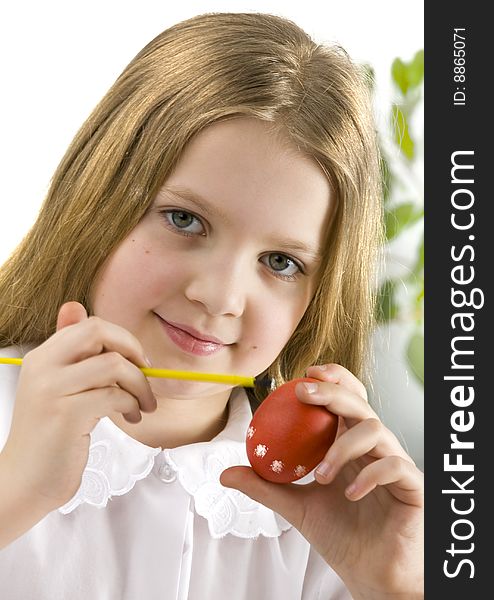 Happy little girl painting easter eggs