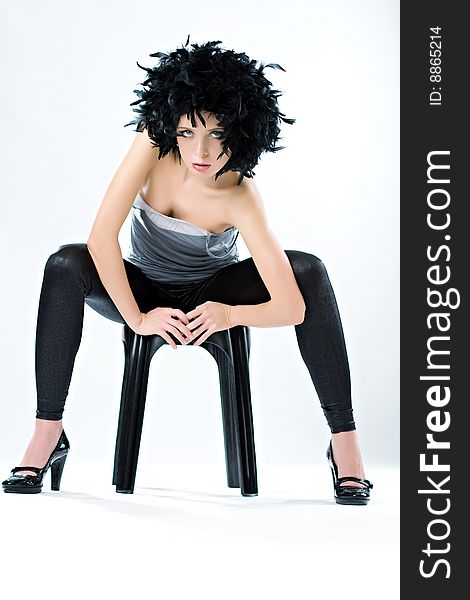Beautiful fashionable woman on the chair in the dynamic pose. Beautiful fashionable woman on the chair in the dynamic pose.
