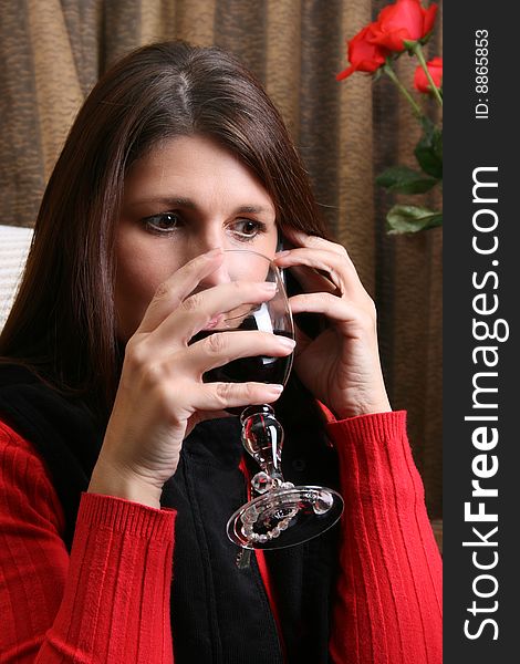 Mature female drinking wine while on the phone. Mature female drinking wine while on the phone