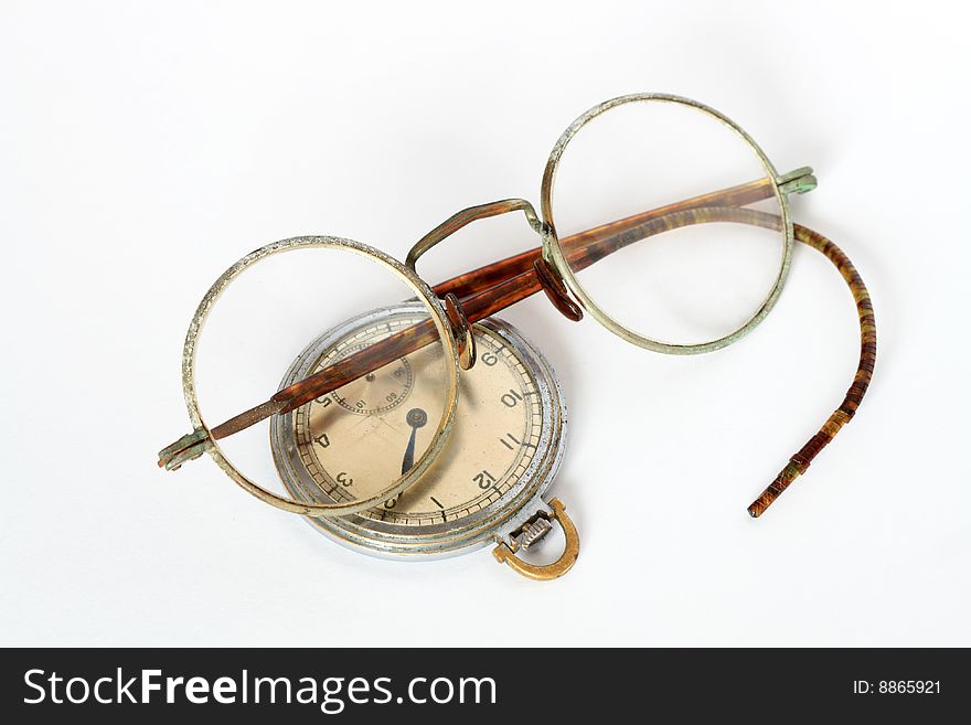 Vintage spectacles and watch lying on white background. Vintage spectacles and watch lying on white background