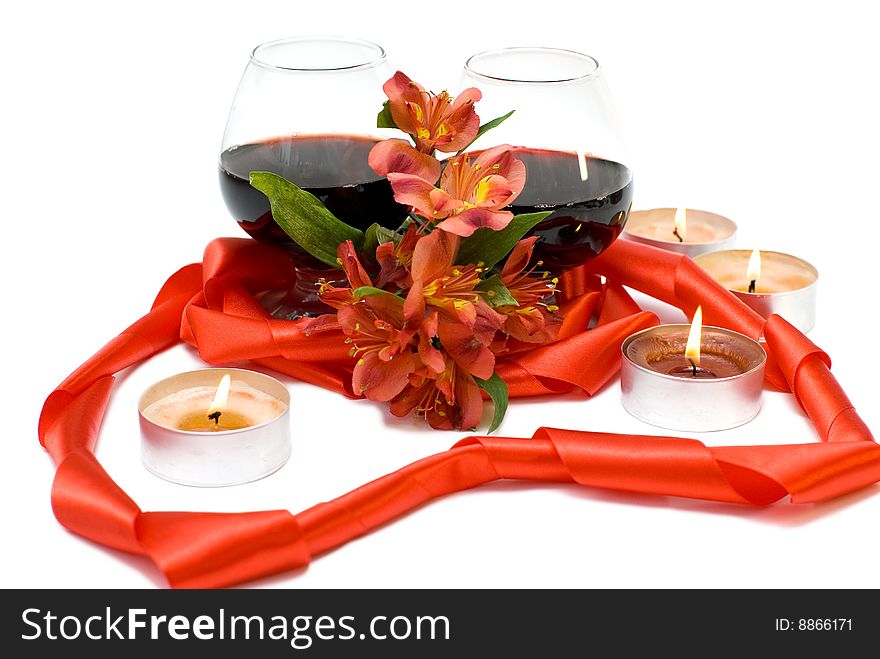 Two glasses of red wine combined with ribbon and flower. Two glasses of red wine combined with ribbon and flower.