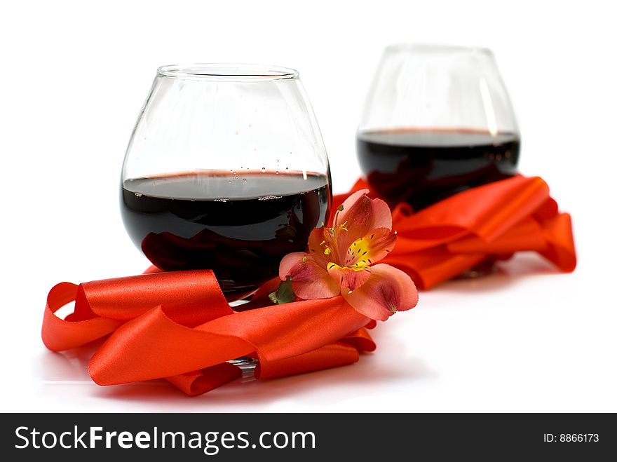 Two glasses of red wine combined with ribbon and flower. Two glasses of red wine combined with ribbon and flower.
