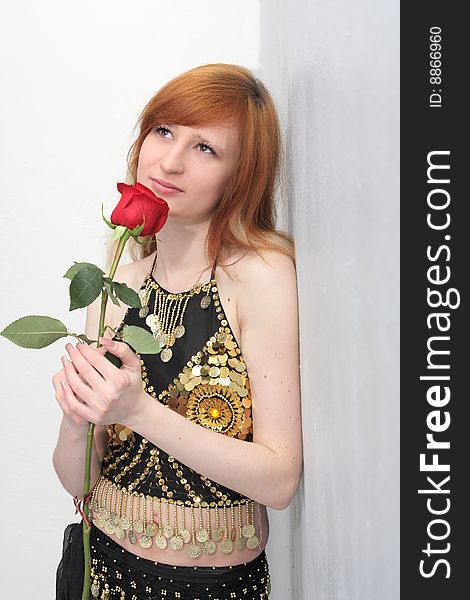 Girl with a red rose in a suit for belly dance