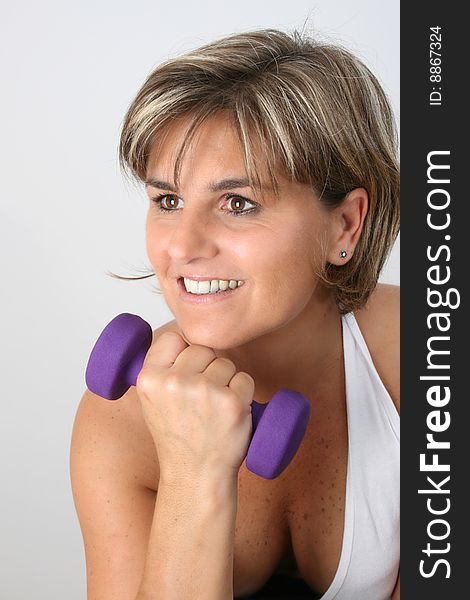 Friendly mature female exercising with small weights. Friendly mature female exercising with small weights