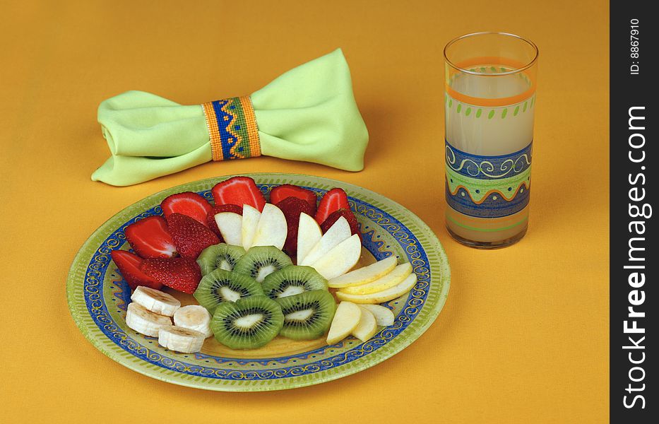 Useful breakfast - fruit salad and a glass of juice of a grapefruit, a decorative napkin