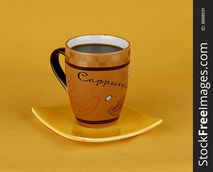 Coffee cup with a saucer on a yellow background