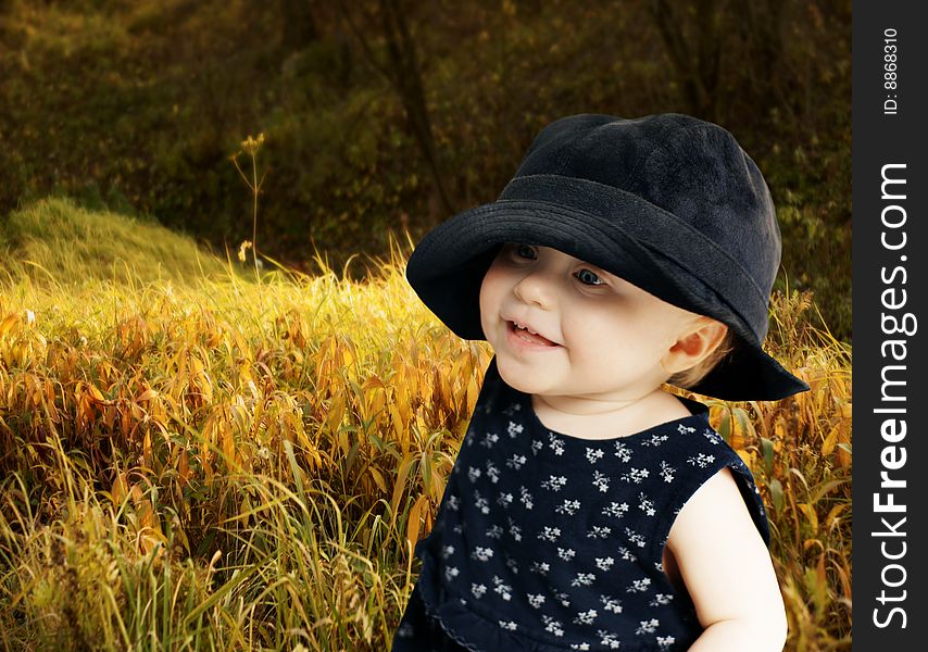 Cheerful child walks on autumn meadow