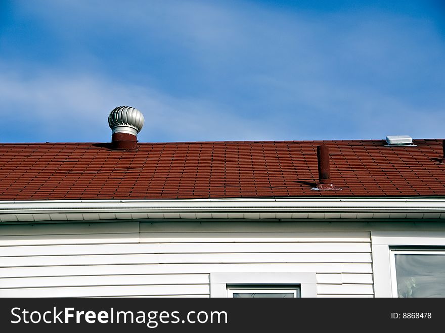 A view of the roof top with a vent on an urban home.