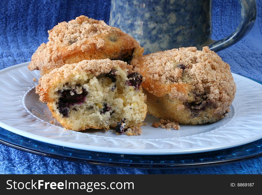 Streusal-topped blueberry muffins with blue coffee cup. Streusal-topped blueberry muffins with blue coffee cup