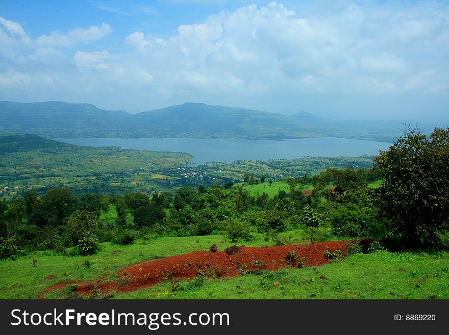 A beautiful landscape scene with river ,mountain and red soil.