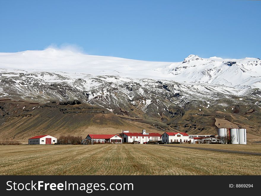 Small rural farming community in Iceland set beneath a glacier