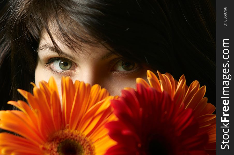 Young beautiful brunette woman's portrait with flowers