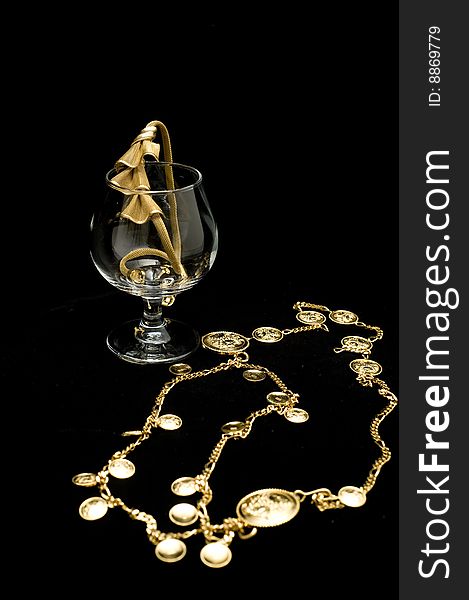 Costume jewelery placed on a glass isolated on black background