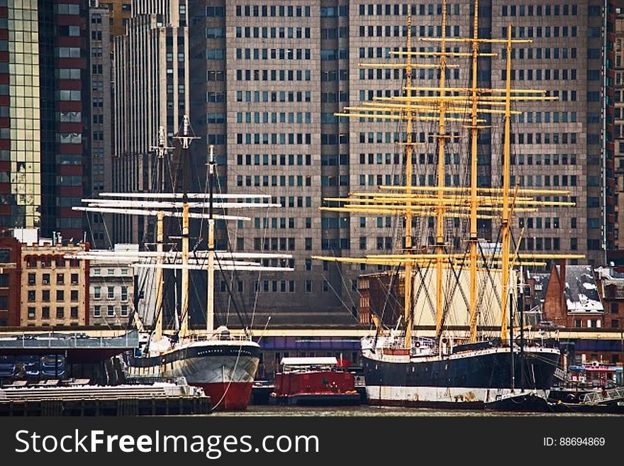 Black White and Yellow Boat Beside Gray Red and White Boat