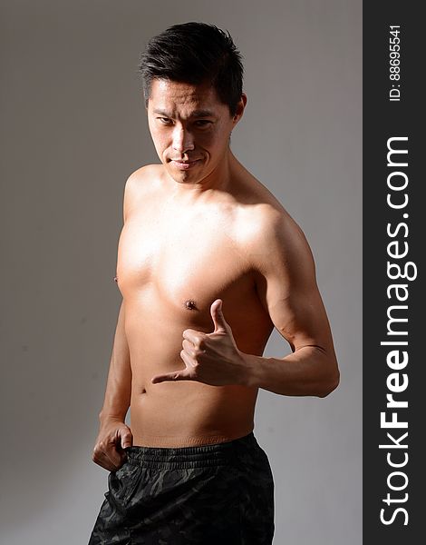 A young Asian man with bare upper body.
