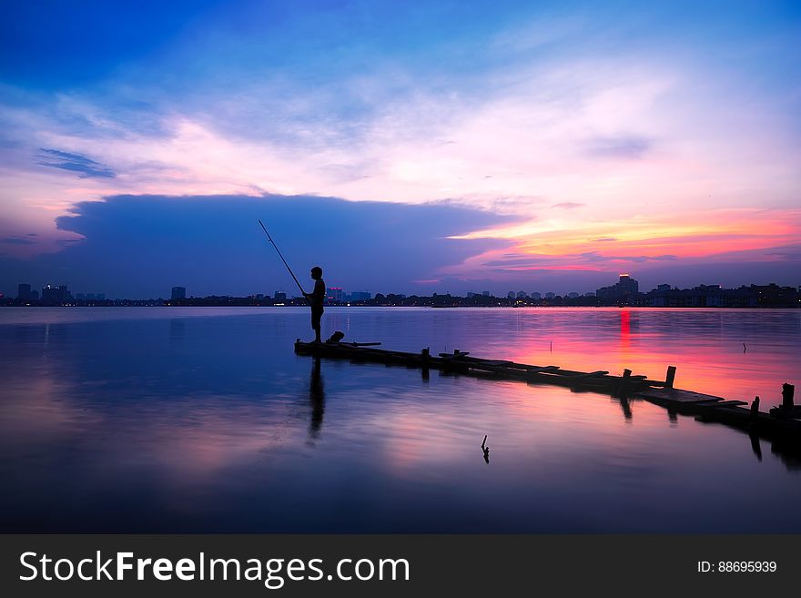 A man fishing at sunset. A man fishing at sunset.