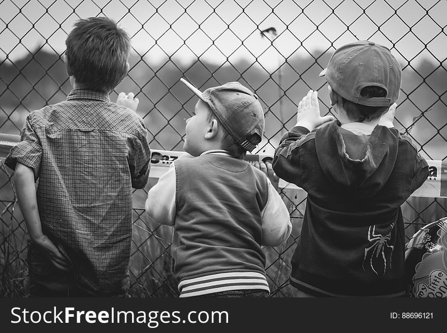 Boys Standing By Wire Fence