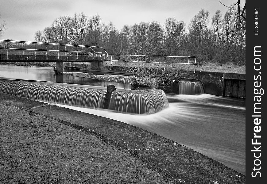 A black and white photo of a river with a weir. A black and white photo of a river with a weir.