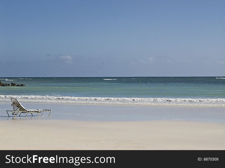 Lone beach chair on a Caribbean beach in Freeport Grand Bahama Island