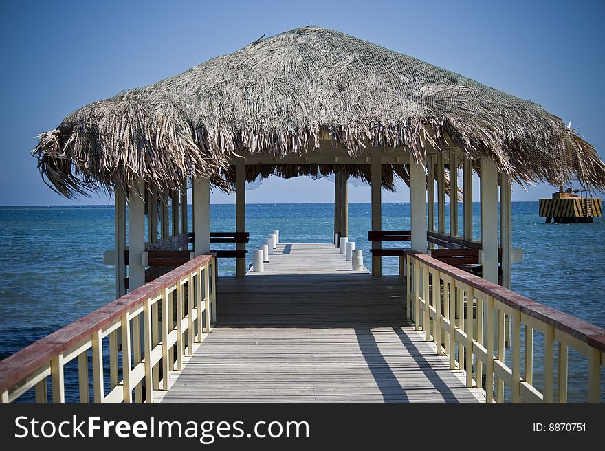 Pristine ocean seen through thatch roof on pier. Pristine ocean seen through thatch roof on pier.