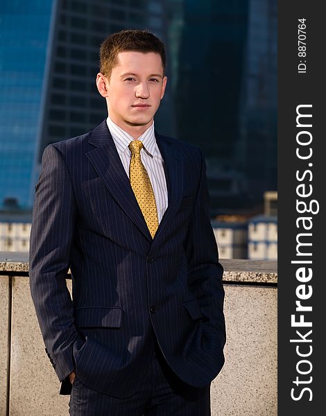 Portrait of young friendly businessman outdoors