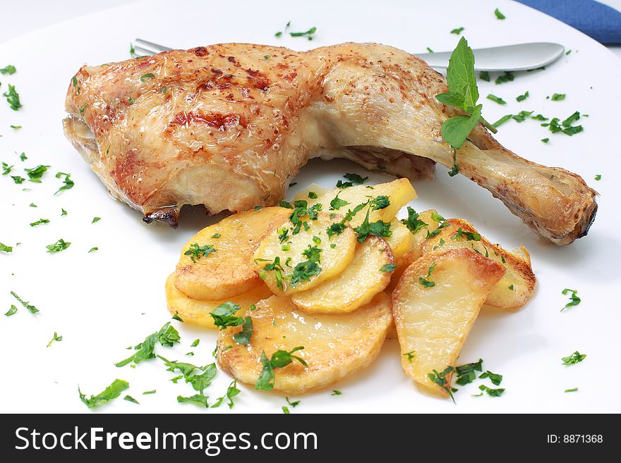 Grilled chicken leg with potato and parsley