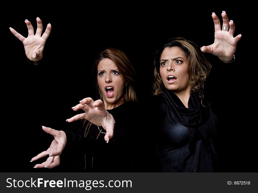 A portrait of surprised young women showing hand gesture