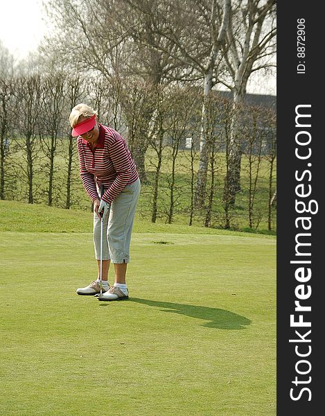 Female golfer putting on the green